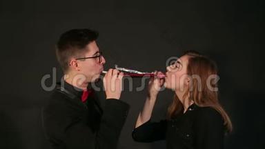 快乐的一对夫妇在聚会上戴着节日喇叭。